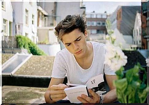 A young person reading a book on the rooftops.