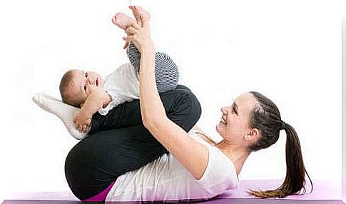 A mother practices yoga with her baby