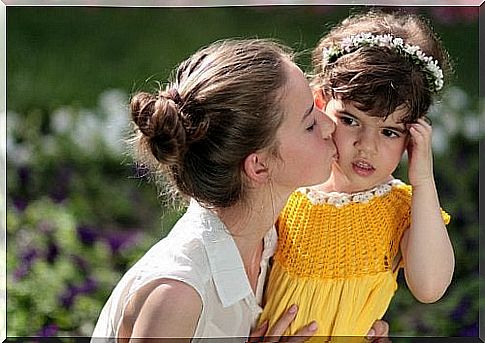 A little girl kissed by her aunt