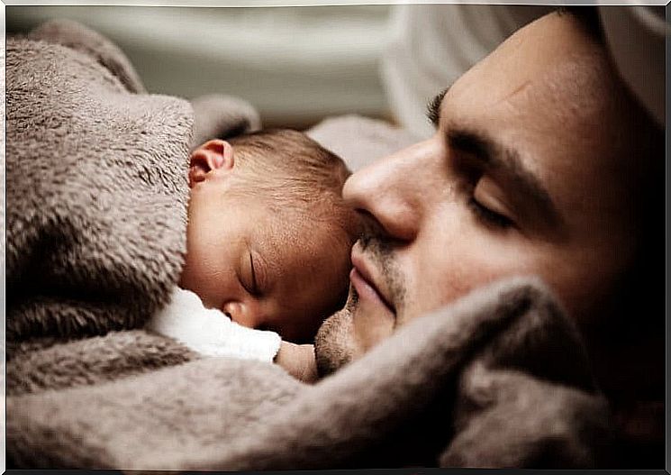 Infant deeply asleep on his daddy