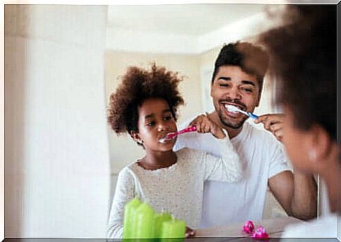 father and daughter brushing their teeth