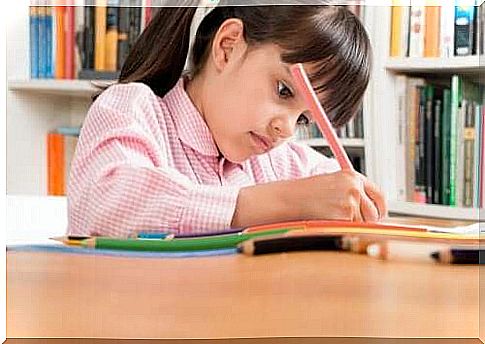 A little girl writing in a notebook.