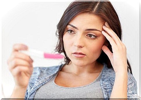 A woman looking at a pregnancy test.