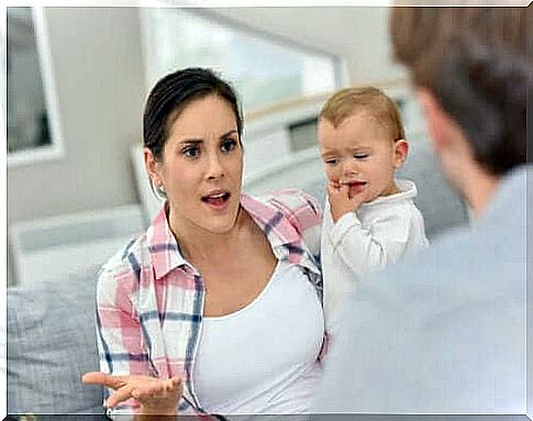 mother holding her baby and arguing with her spouse