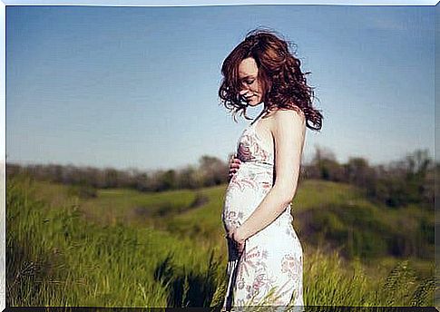 A pregnant woman in a field.