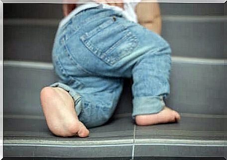 A young child climbing the stairs. 