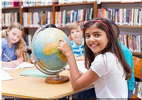 A student shows the world map with her finger