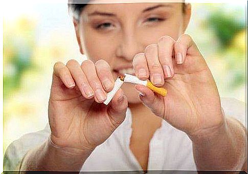 A woman breaks a cigarette in half