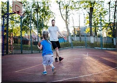 father and daughter play basketball