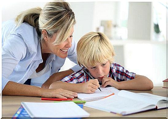 A mother encouraging her child in front of her notebooks 