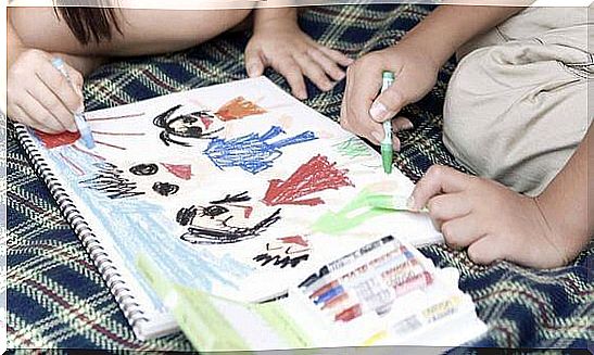 Two children draw in pencil on a notebook, an activity that can stimulate fine motor skills