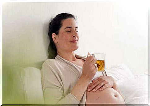 A pregnant woman drinking tea. 