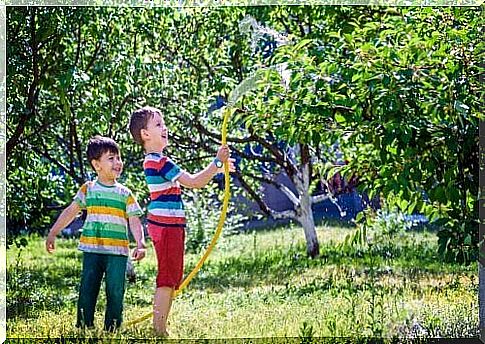 Children watering the plants in the garden.